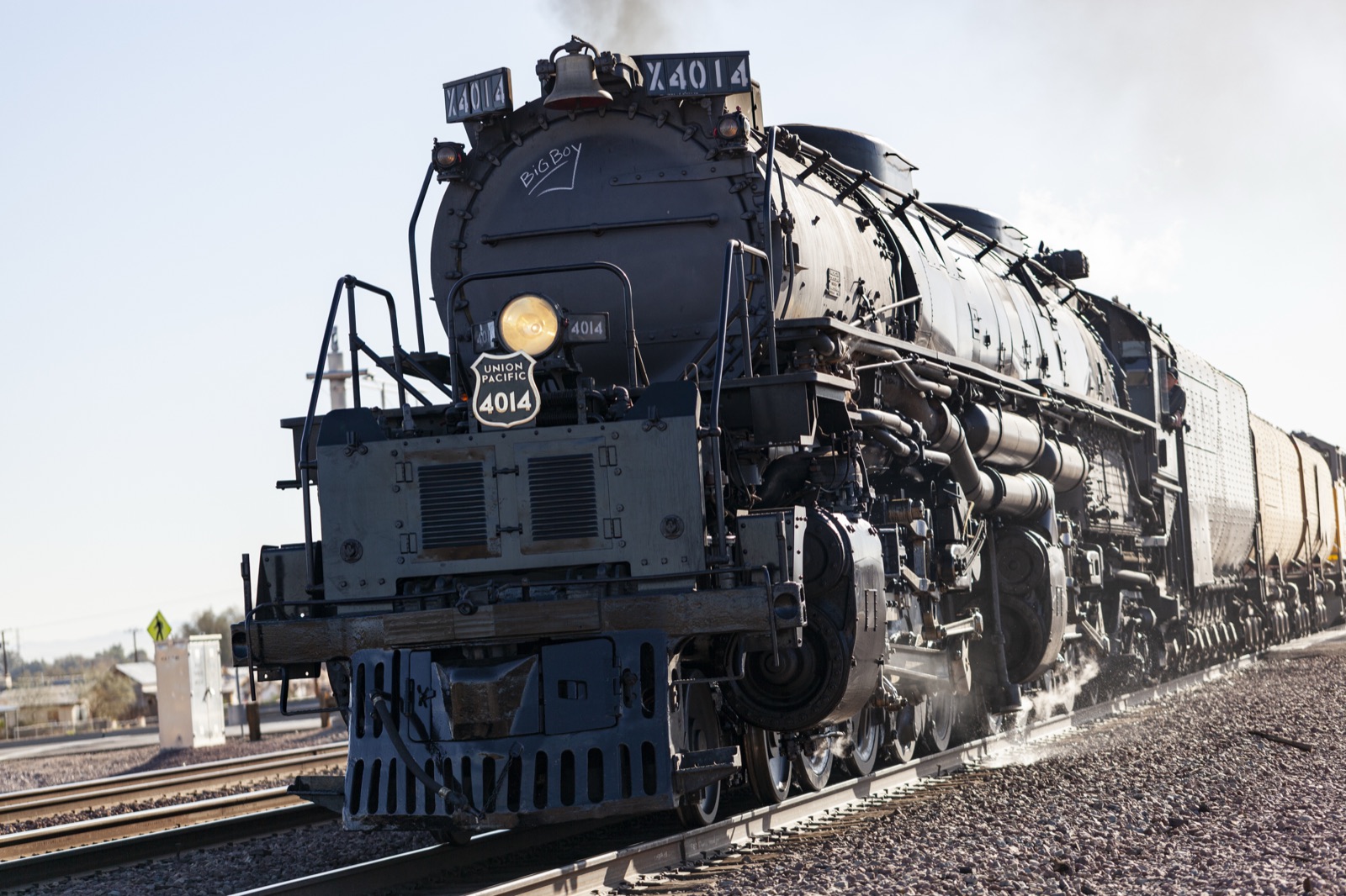 Big Boy 4014 under steam, smoke and steam billowing from the stack as the locomotive accelerates along the main line.